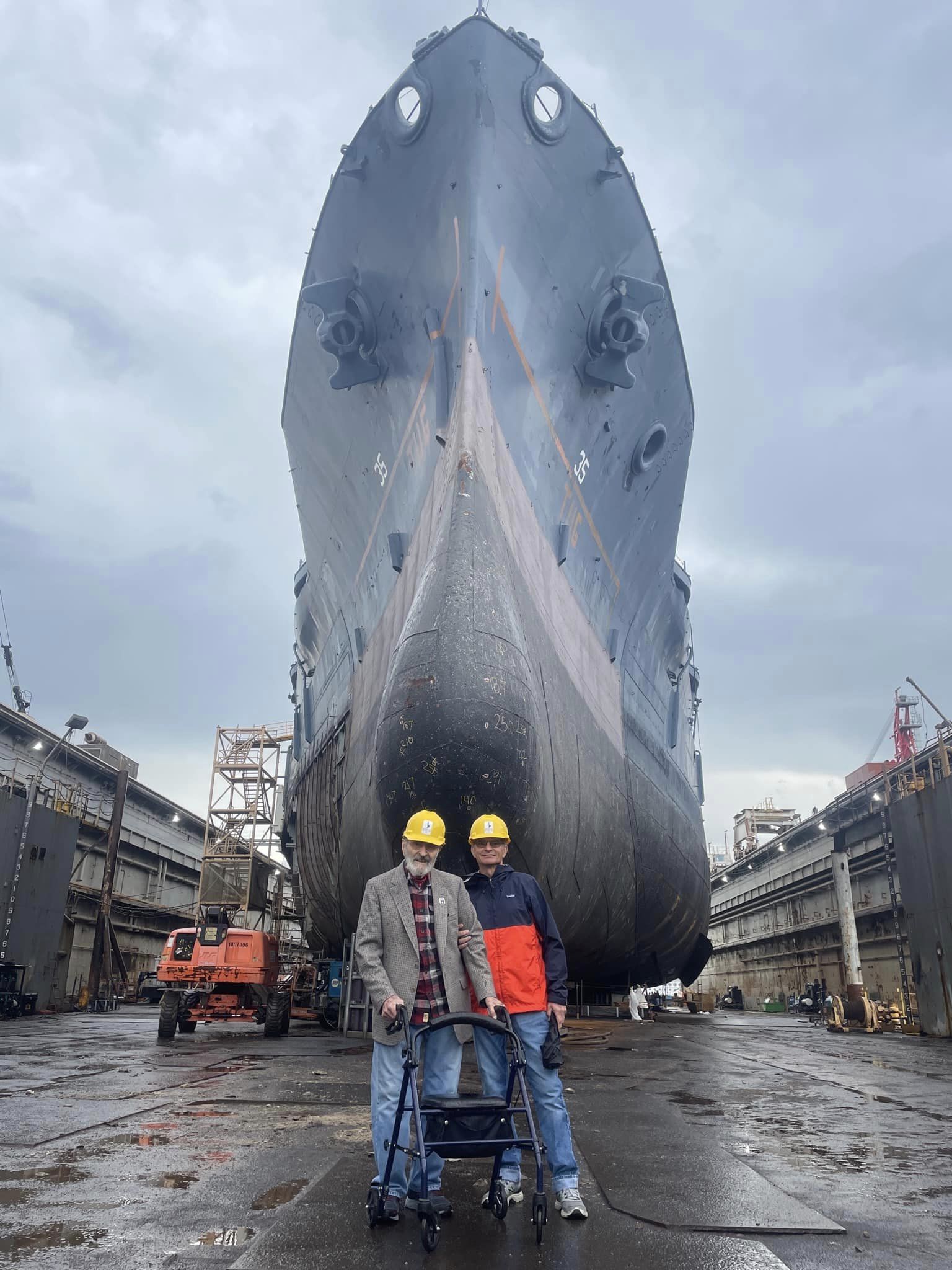 two men in front of a ship